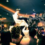 Bar Mitzvah celebration. Brother of the Bar Mitzvah boy is held up on a chair. It is traditional for the child and his family to be raised on chairs during the party.